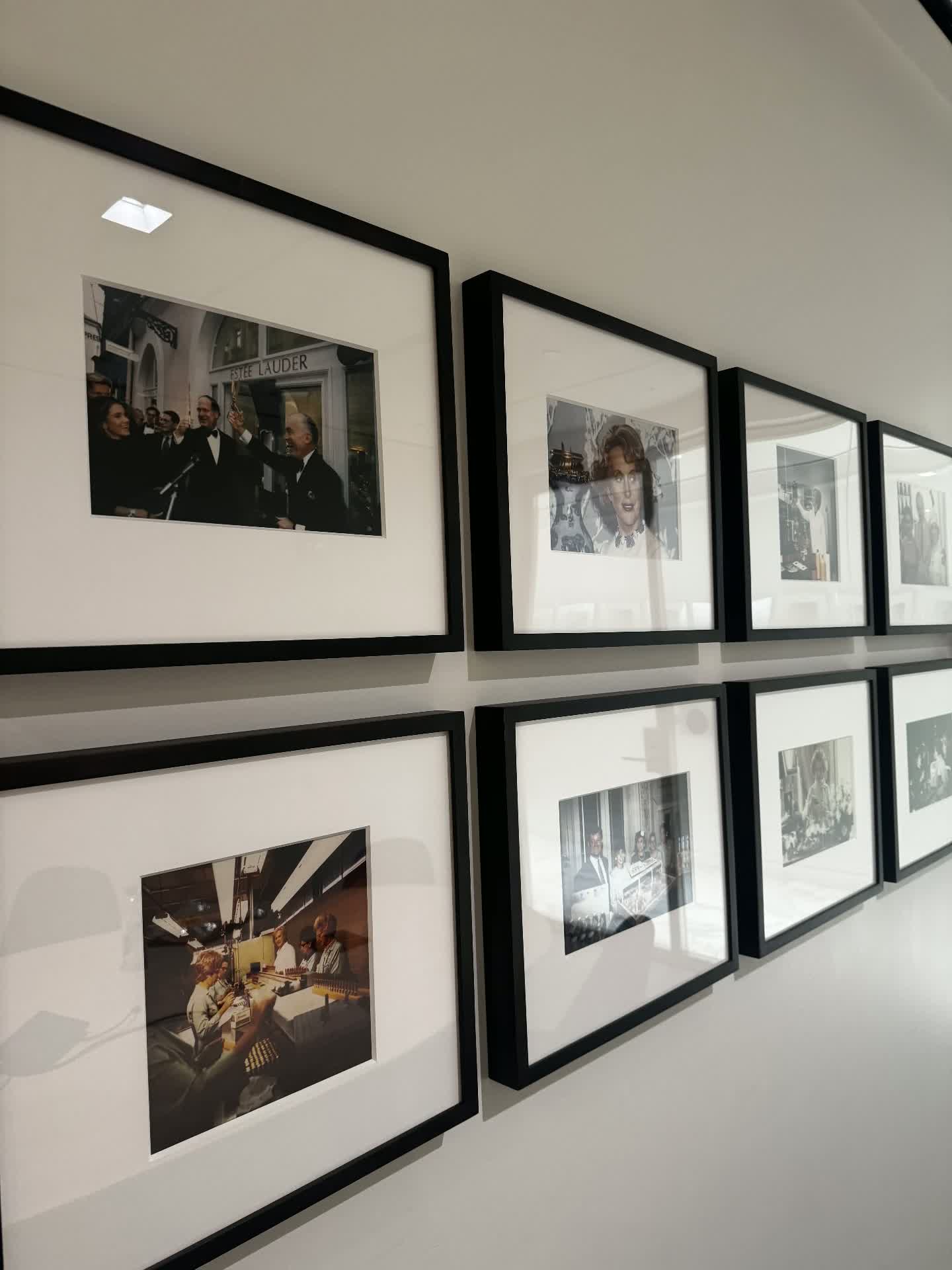 Framed archival Estée Lauder heritage photographs on an office wall