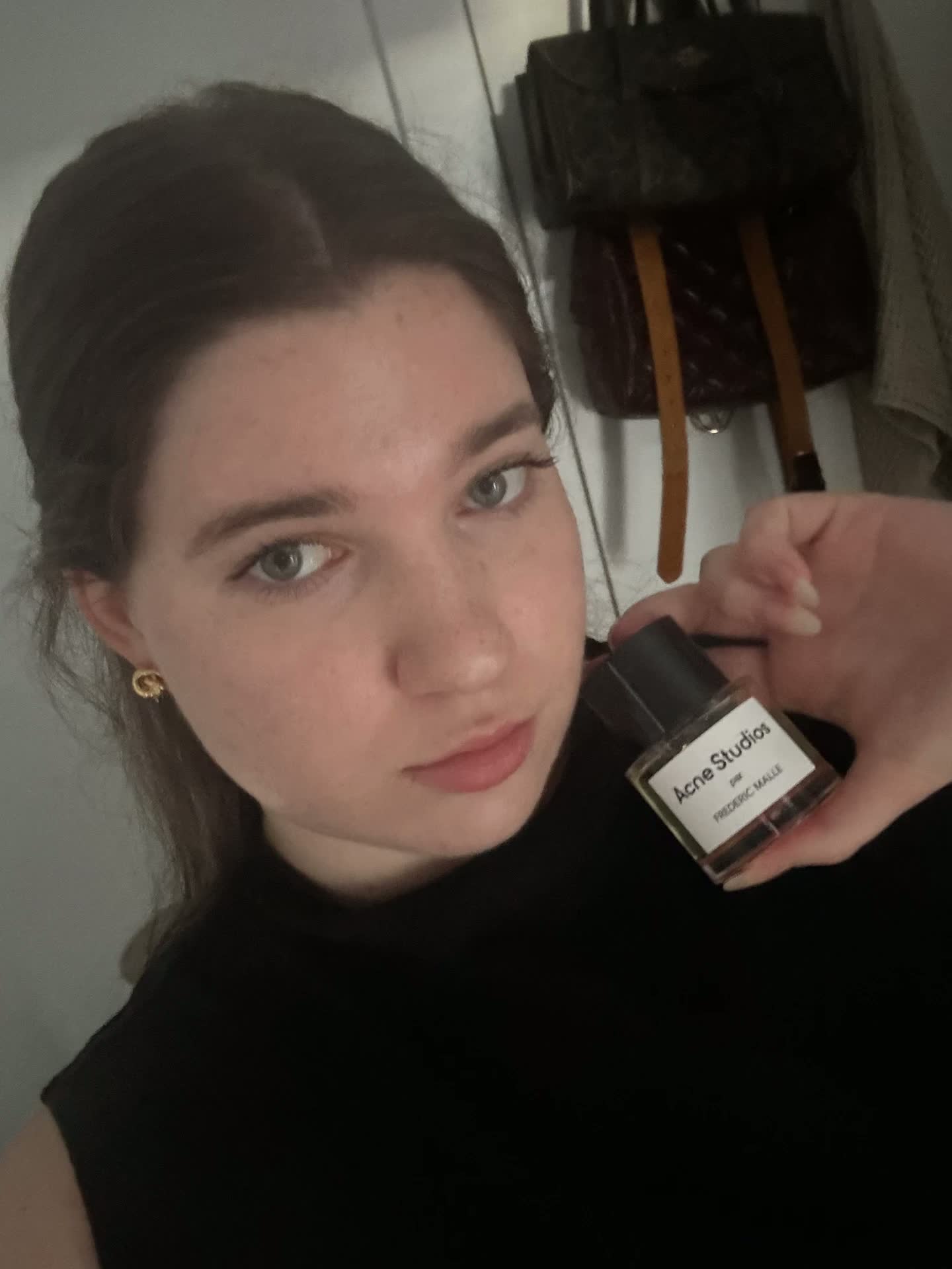 Anna holding an Acne Studios par Frédéric Malle fragrance bottle